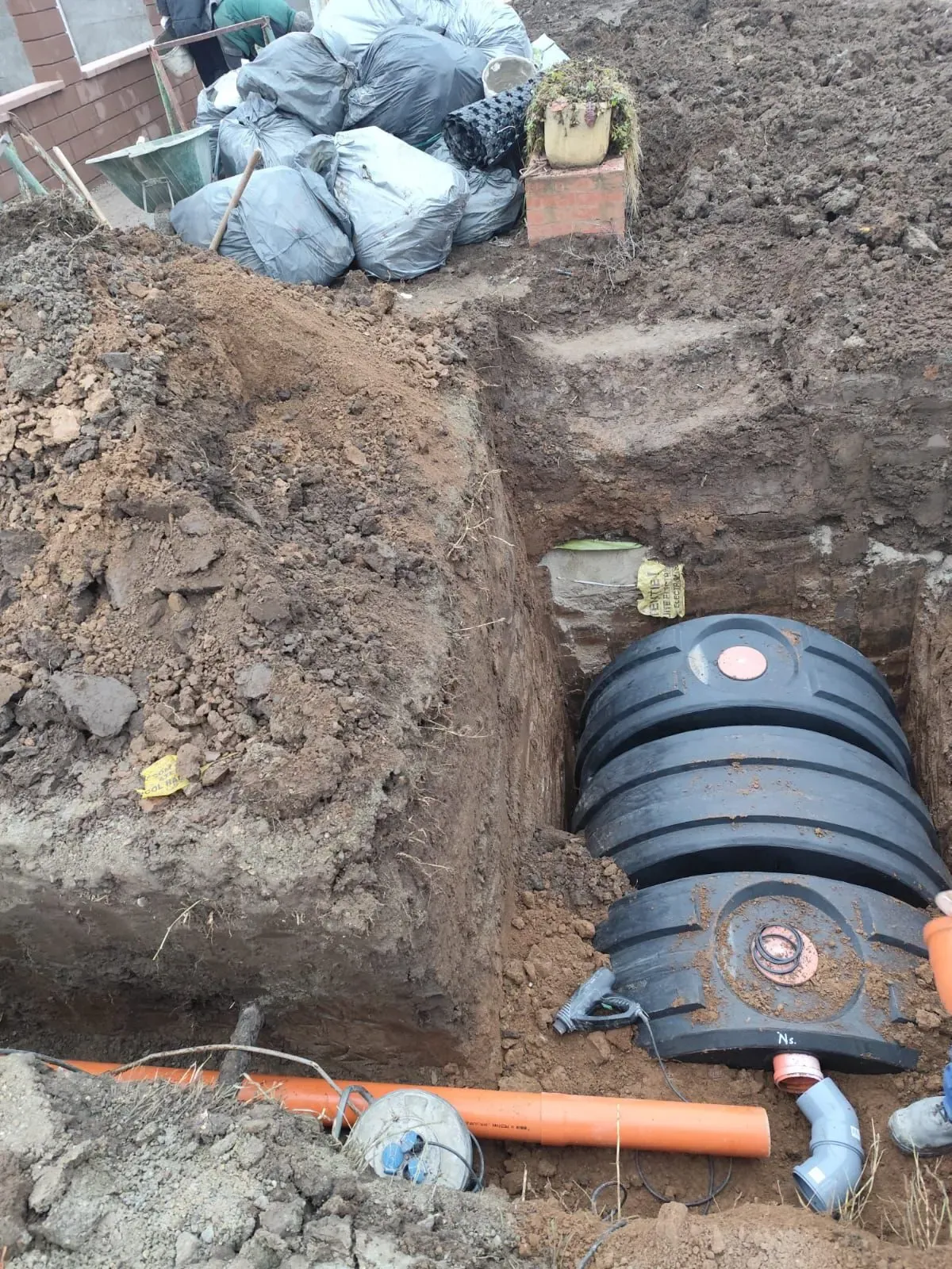 Rezervor din polietilenă poziționat în excavație, cu gurile de acces deasupra